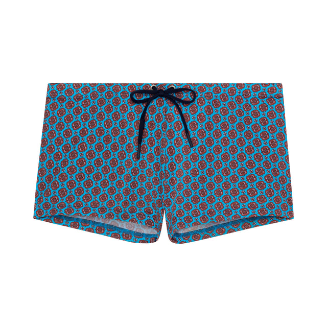 Blue swim shorts with red pattern on a white background