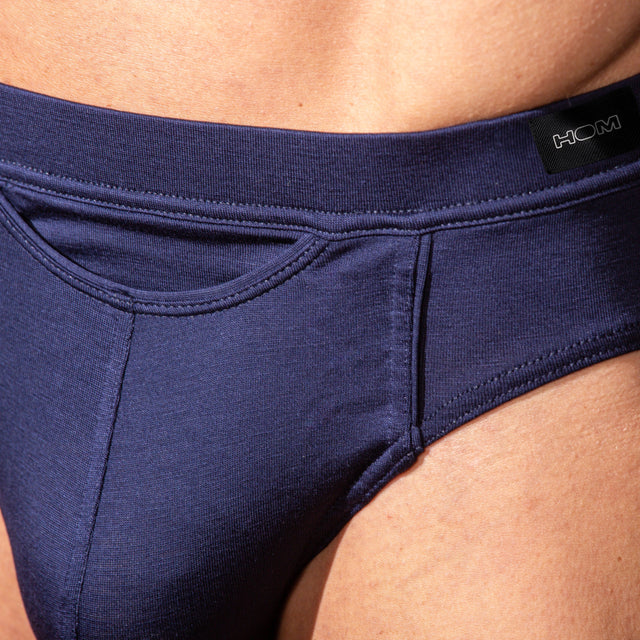 Navy blue underwear with a brand label on a person's waist.