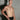 Man wearing black briefs against a gray tiled wall