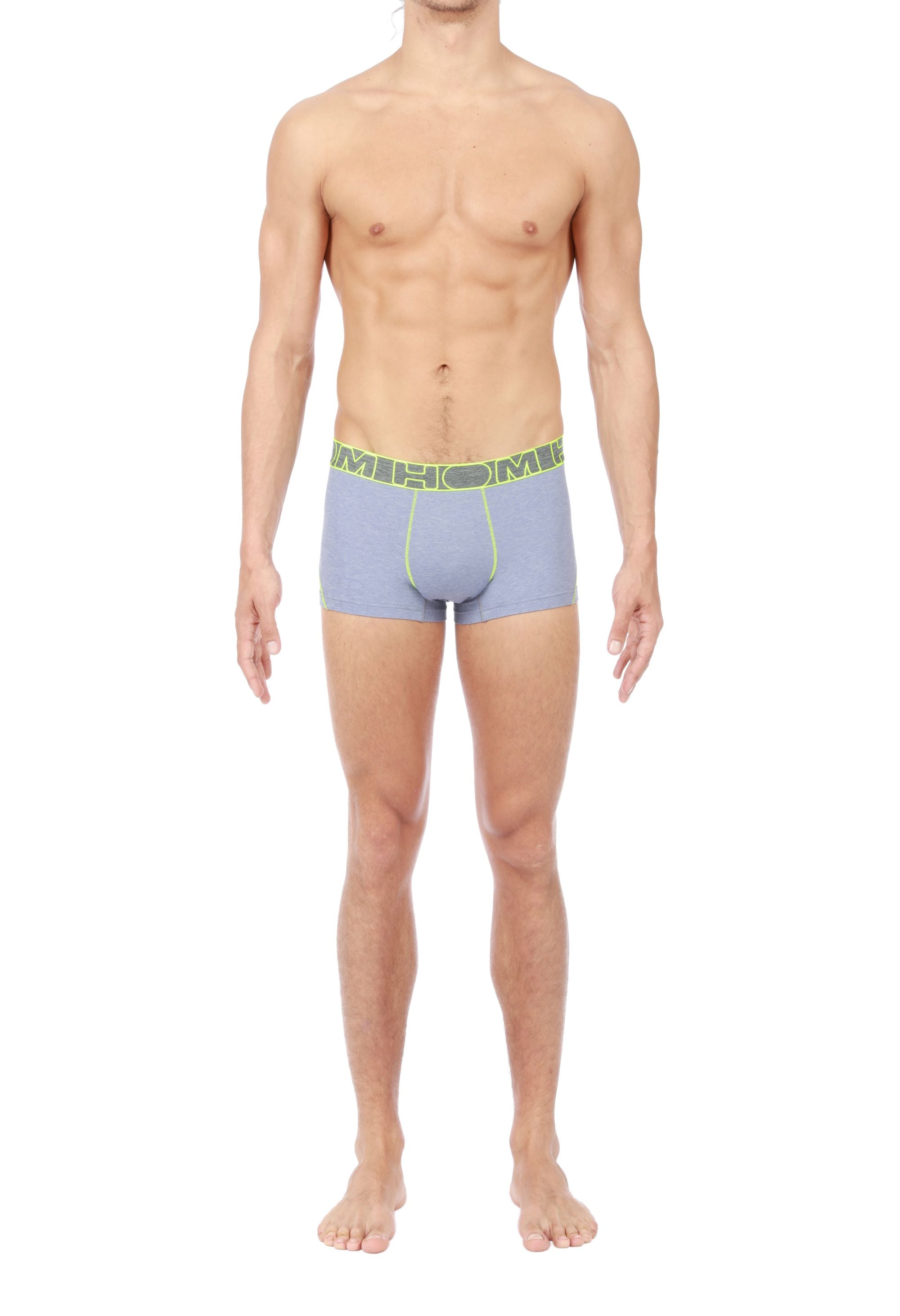 Man wearing grey boxer briefs with a green waistband on a white background