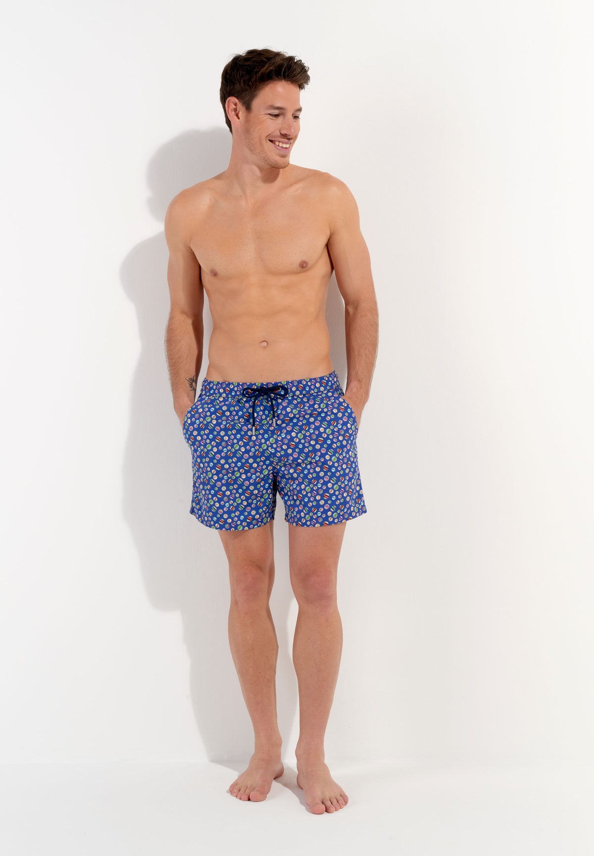 A pair of navy blue beach boxer shorts with a colorful marble print and a drawstring waist.