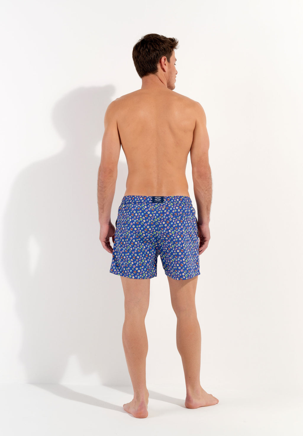 A pair of navy blue beach boxer shorts with a colorful marble print and a drawstring waist.