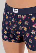 male model wearing a pair of navy blue boxer briefs with a multicolored heart pattern and a wide red elastic waistband.