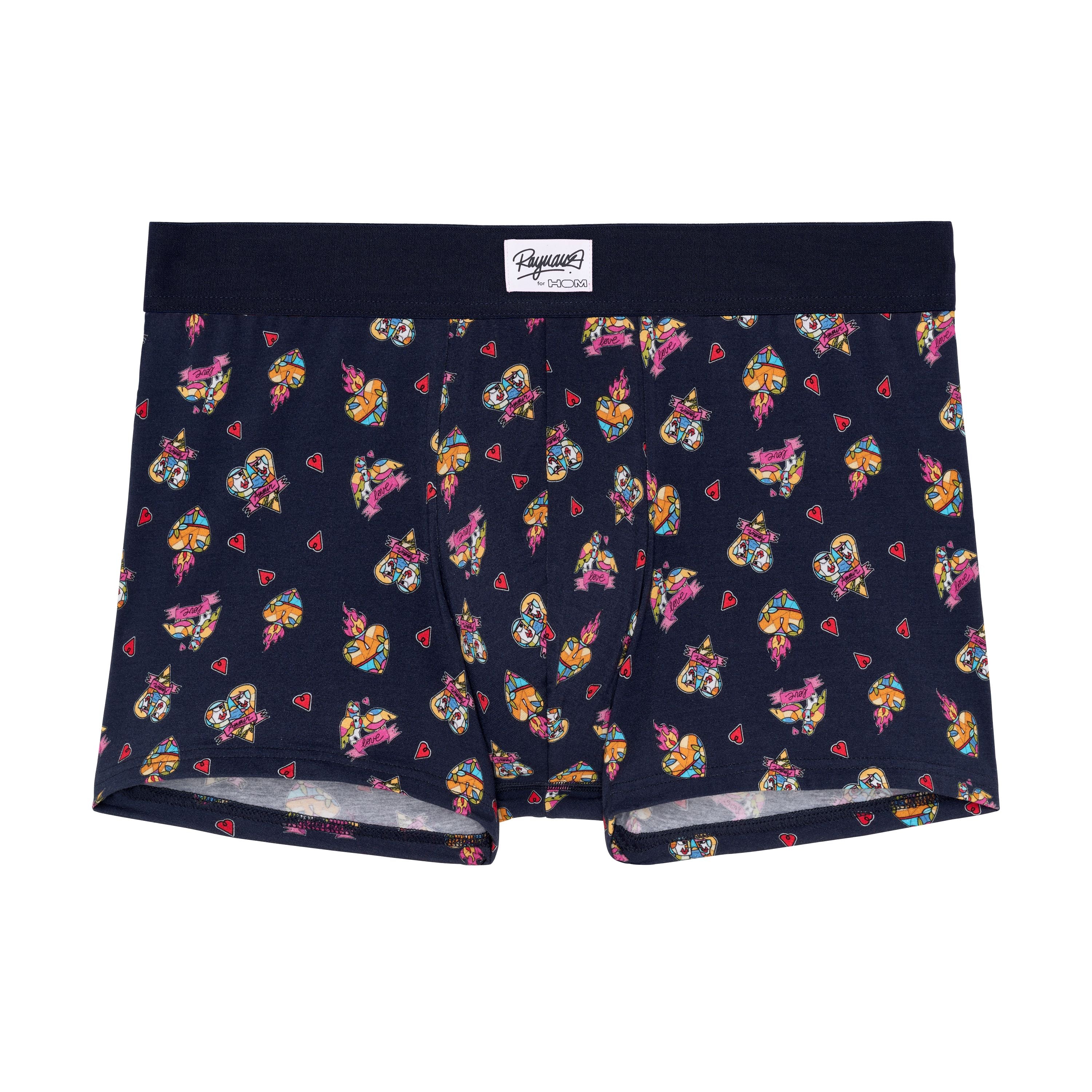 A pair of navy blue boxer briefs with a multicolored heart pattern and a wide red elastic waistband.