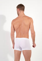 Man wearing white boxer briefs on a plain background