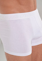 White boxer briefs worn by a person with a neutral background