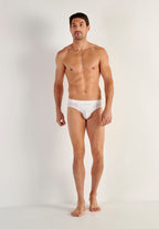 Man wearing a white men's underwear on a plain background