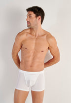 Man wearing white underwear against a plain background
