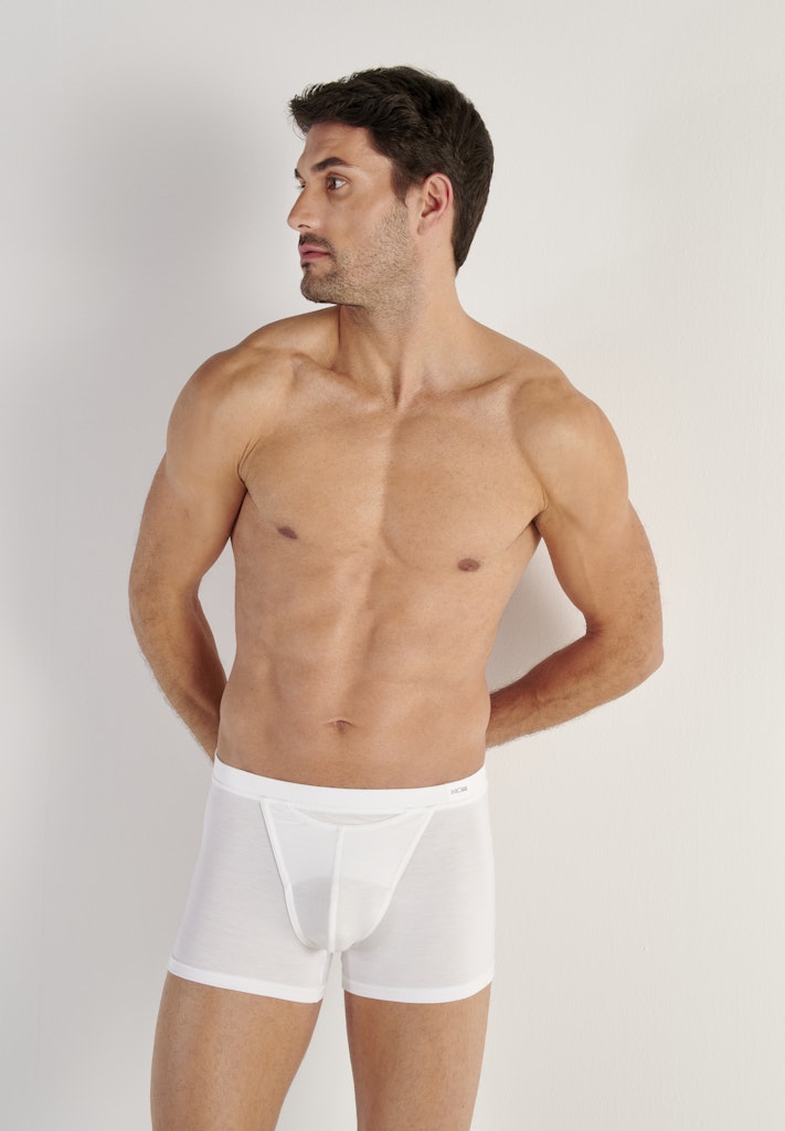 Man wearing white underwear against a plain background