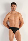 Man wearing black briefs against a plain background