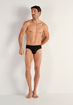 Man wearing a black underwear on a plain background