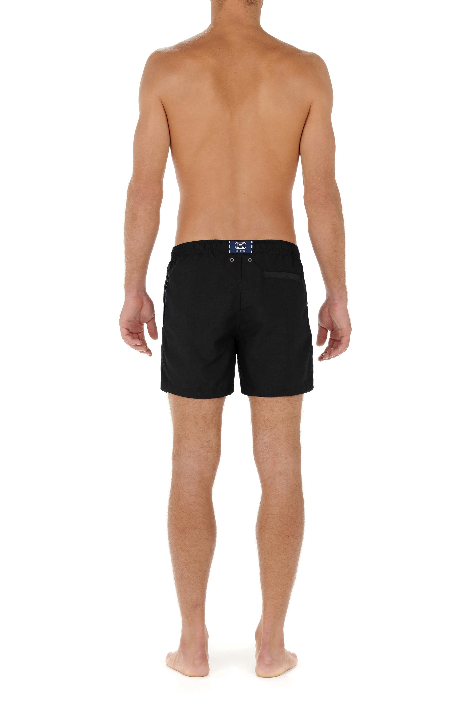 Person wearing black swim shorts on a white background