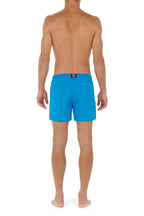 Person wearing blue swim shorts on a white background