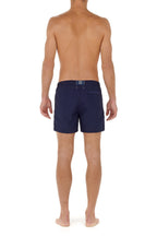 Person wearing navy blue swim shorts on a white background