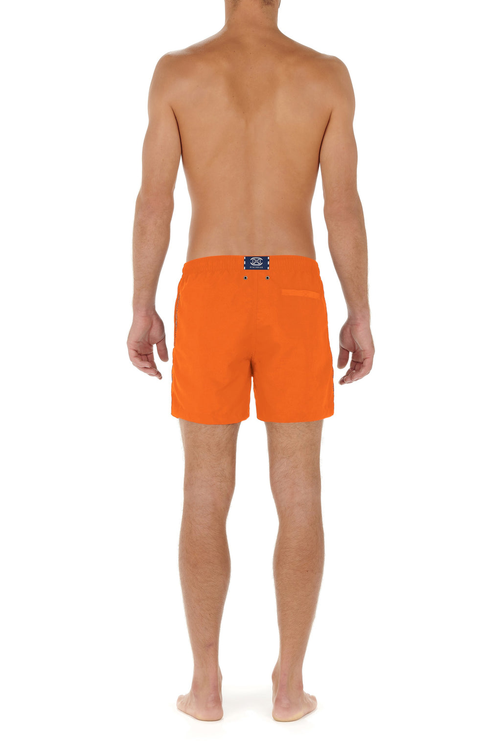 Person wearing bright orange swim shorts on a white background