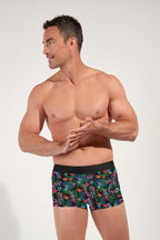 Man wearing colorful floral-patterned underwear on a plain background