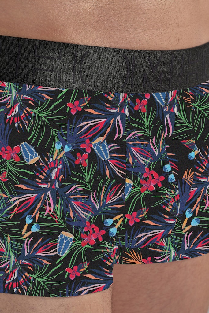 Floral-patterned boxer briefs with a black waistband on a person wearing them.