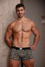 Man wearing colorful patterned underwear against a neutral background
