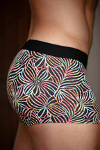 Multicolored patterned shorts with a black waistband on a male model