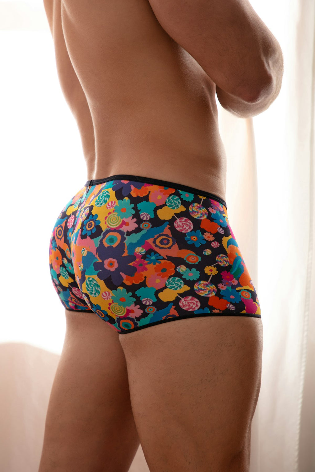 Colorful patterned underwear worn by a person against a neutral background