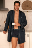 Man wearing a navy robe and underwear in a kitchen setting